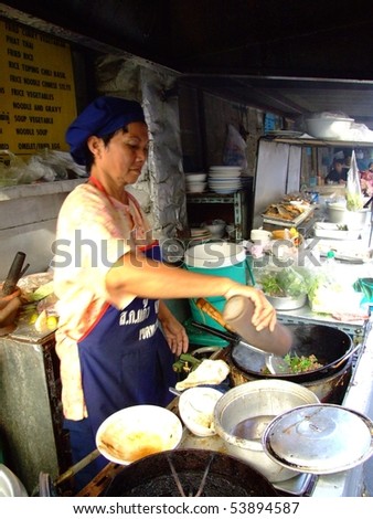 BANGKOK, THAILAND - APRIL 3: Thai woman cooks food in an outdoor kitchen April 3, 2007 in Bangkok.