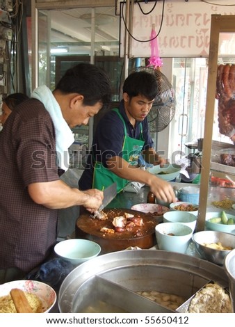 BANGKOK, THAILAND - OCTOBER 28: Thai men cook food in an outdoor kitchen  on October 28, 2005 in Bangkok.