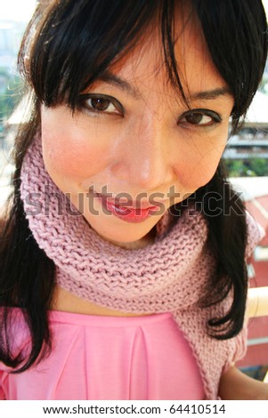 Beautiful asian girl outdoors wearing scarf.