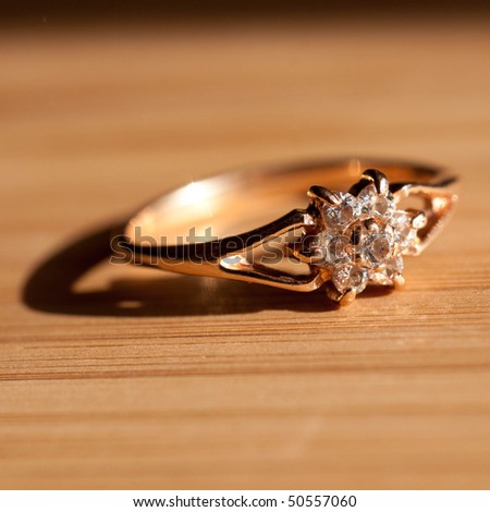 a golden ring on wooden desk in the sunshine