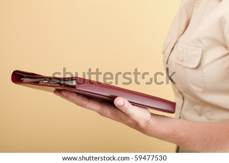 The woman holds the business book for notes