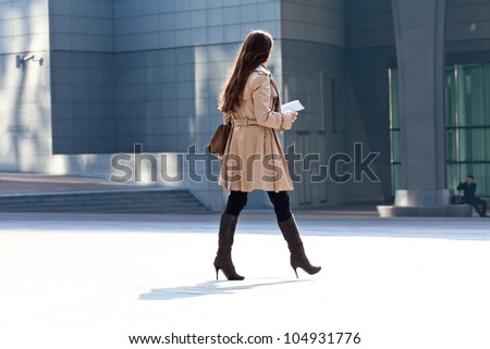 People walking against the light background of an urban landscape.