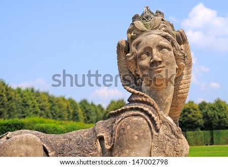 antique stone sculpture of female sphinx figure in nature surrounding  in dresden, saxony, germany