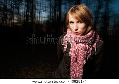 Beautiful girl in the woods in the evening looking thoughtfully into the camera