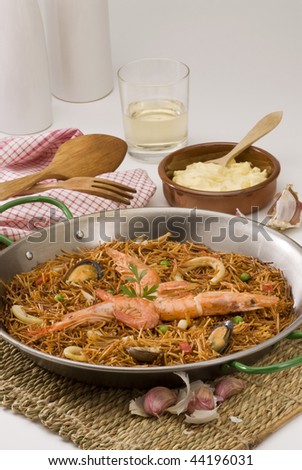 Spanish cuisine. Fideua. Seafood spaghetti cooked in a typical paellera, served with garlic mayonnaise sauce.