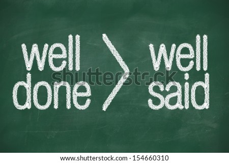 interpretation of phrase Well done is better than well said handwritten on blackboard
