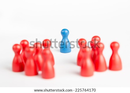 Center of attention blue pawn surrounded and praised by red pawns