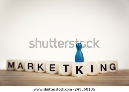 Market king concept: King pawn on the word Marketking spelled by toy dice