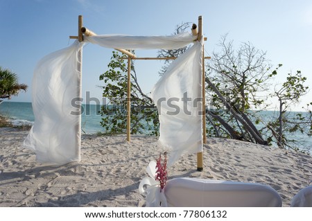 Wedding on the beach, wind blowing the canopy on the chuppa arbor