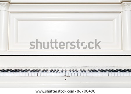A white upright piano, seen from the perspective of the player.