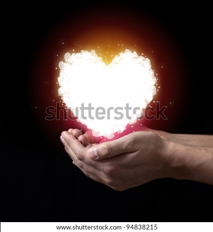 St Valentine`s heart in hand over dark background.
