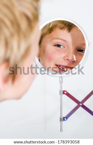 boy smiling and looking in a vanity mirror