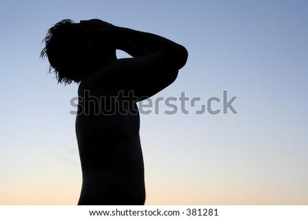 Silhouette of man with hands on his face, as if he has just lost an important match or received very bad news
