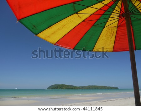 View on tropical island from underneath a beach umbrella