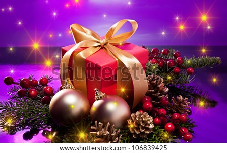 Red present box in a Christmas setting with glowing stars over a purple background