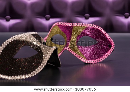Elegant mask for Masquerade in front of a button tufted purple silk background