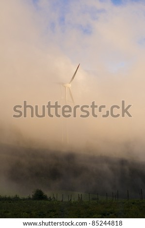 Windmill in the countryside during fog in the evening