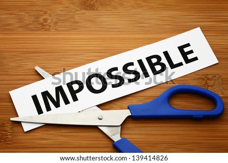 Word impossible cut to possible over wood background