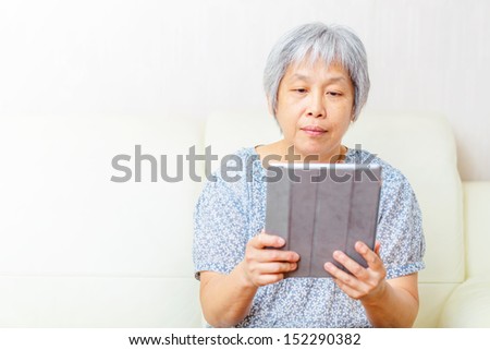 Asian old woman using tablet