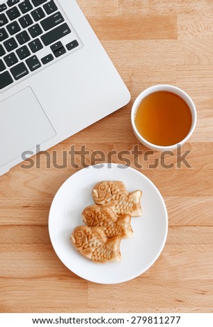 Computer pc with japanese snack and tea