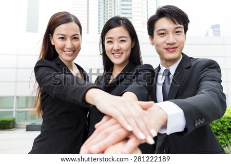 Business team mate putting their hands on top of each other