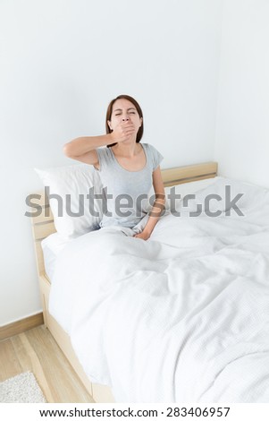 Woman in pyjamas yawning