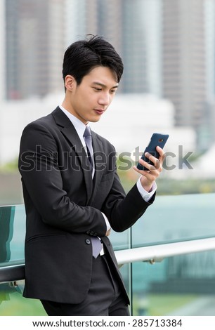 Asian businessman watch on cellphone