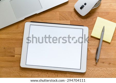 Business office table with table pc presenting a blank screen for advertising