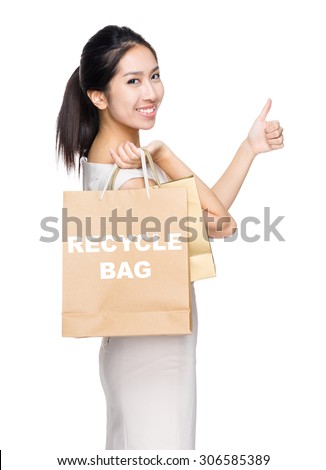 Woman with thumb up gesture and holding shopping bag for showing recycle bag