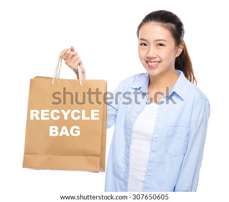 Young woman with shopping bag ans showing recycle bag