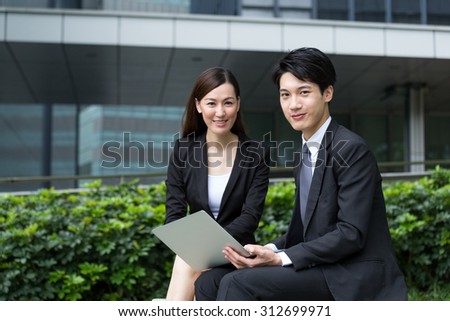 Two business people using the laptop computer at outdoor