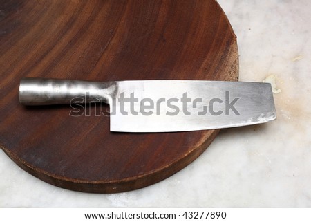 Closeup image of chinese kitchen knife on cutting board.