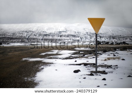 Road signs near an icy road in a winter landscape in Iceland