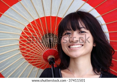 Beautiful Japanese girl happy while holding a Japanese rice paper umbrella