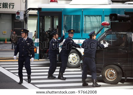 TOKYO - MARCH 11: Police stopping right-wing protesters near the Imperial Palace on March 11, 2012 in Japan. Radicals often use public holidays and anniversaries to promote nationalist propaganda.