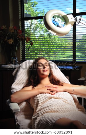 Young woman on chair undergoing spa treatment