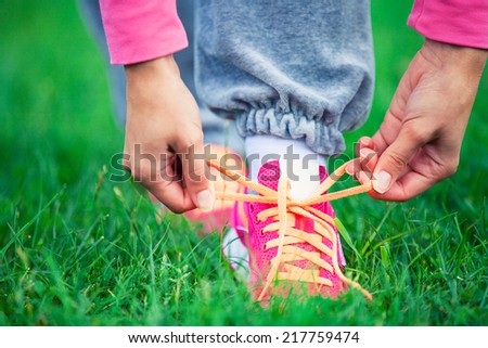 A young woman laces up laces