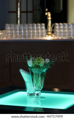 Hotel ballroom with luminous bar tables and a bar unit setup for a fancy reception.