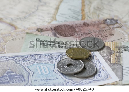 Egyptian coins and notes on map of Middle East, selective focus