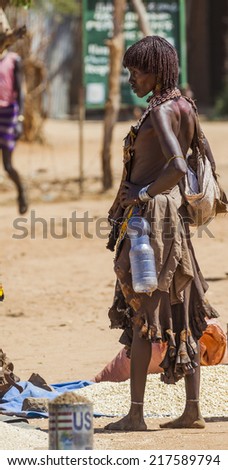 TURMI, OMO VALLEY, ETHIOPIA - DECEMBER 30, 2013: Unidentified Hamar woman seller at village market. Weekly markets are important events in Omo Valley tribal life.