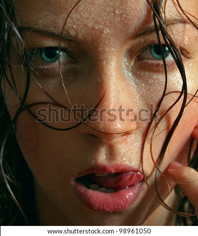 Wet woman portrait with water drops on the face and tip tongue hanging out