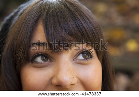 A close up of a young female\'s eyes looking up and smiling.