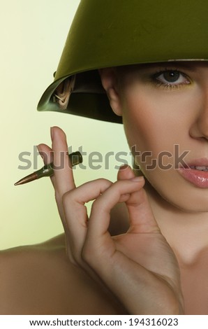 Woman with a cartridge in the army helmet
