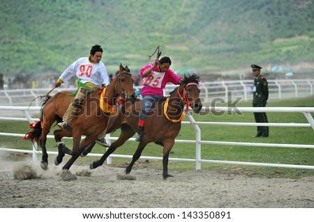 ZHONGDIAN - JUNE 11: participants race during the Shangrila horse racing festival on June 11, 2013 in Zhongdian, China. This festival is the most important horse racing festival in Southwest China.