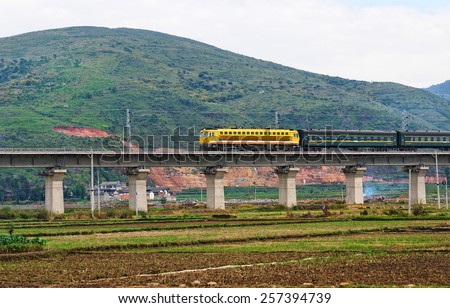DALI, CHINA - AUGUST 3: new Chinese train runs through the countryside on 3 August, 2013 in Dali, China. Railway network is rapidly being expanded and at present China has over 100.000 km of railway.