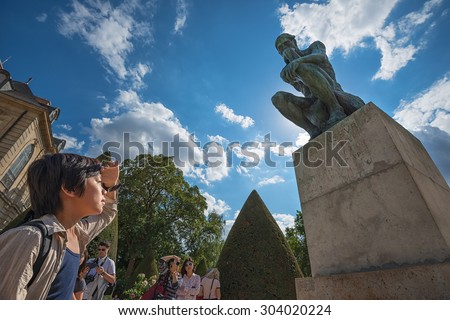 PARIS - JULY 25: tourists visiting the statue of the Thinker at the Museum of Rodin on July 25, 2015 in Paris,France.The Thinker is a world famous bronze sculpture made by Auguste Rodin in year 1880.