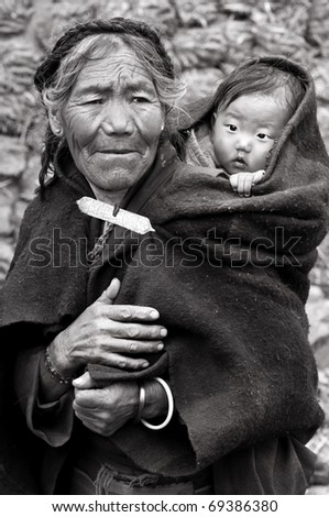 LHASA - MAY 15: Tibetan woman and child circle the holy Jokhang monastery on May 15, 2010 in Lhasa, Tibet. Some devotees walk 108 times around the monastery for good luck
