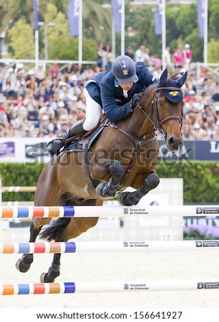 BARCELONA - SEPTEMBER 28: Jens Fredricson from Sweden jumps a horse jumping obstacle at CSIO - Furusiyya Nations Cup Horse Jumping Consolation Competition, on September 28, 2013, in Barcelona, Spain.