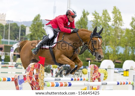 BARCELONA - SEPTEMBER 28: Dieter Kofler from Austria jumps a horse jumping obstacle at CSIO - Furusiyya Nations Cup Horse Jumping Consolation Competition, on September 28, 2013, in Barcelona, Spain.