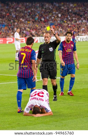 BARCELONA - SEPTEMBER 13: Referee giving yellow card to David Villa during the UEFA Champions League match between FC Barcelona and AC Milan, 2 - 2, on September 13, 2011, in Barcelona, Spain.